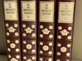 four books are lined up on a shelf in a row