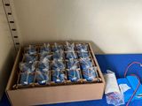 a box of soda bottles and a box of wires on a blue table
