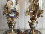 two vases with flowers under glass covers on a table