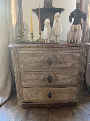 three sheep standing on top of a dresser in a living room