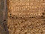 a wicker chair that is sitting on a wooden floor