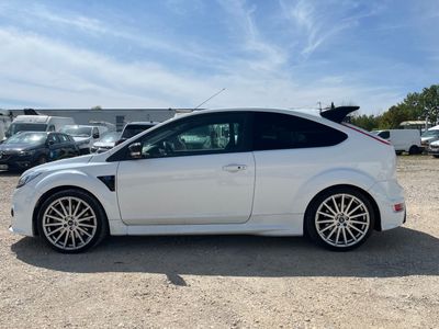 the white ford focus is parked in a lot with other cars
