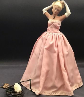 barbie doll in a pink dress with white gloves and a rose