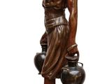 statue of a woman carrying a pot and a pot on a base