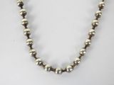 silver and gold beaded necklace on a white background