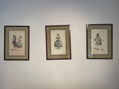 three framed pictures on the wall of a room