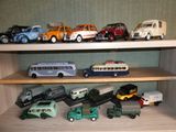de nombreuses petites voitures et de nombreux petits camions sur une étagère dans une pièce