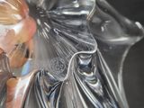 a glass figurine of a woman with a flower on her head