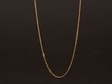 un collier à chaîne en or avec un fermoir en diamant sur fond noir