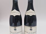 deux bouteilles de vin rouge posées l'une à côté de l'autre sur une surface blanche