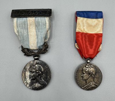 Deux médailles sont représentées sur un fond blanc, ornées d'un ruban rouge, blanc et bleu.