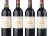 three bottles of red wine are lined up on a white surface