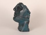 a close up of a sculpture of a head on a white surface