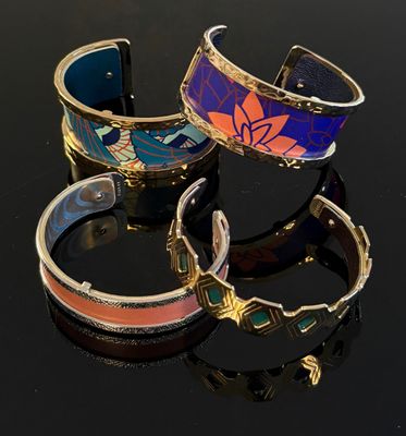 trois bracelets de couleurs différentes sur un fond noir avec des reflets