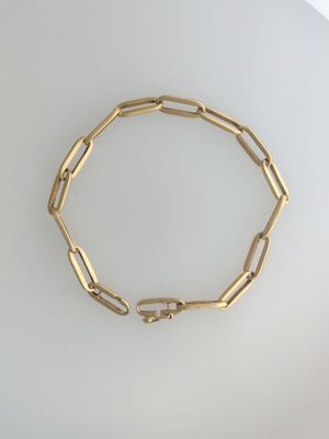 a close up of a gold bracelet on a white surface