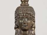 a silver and blue vase with a face on it