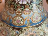 a large vase with a gold handle on a table