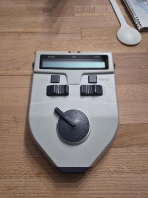 une calculatrice posée sur une table en bois à côté d'un téléphone portable