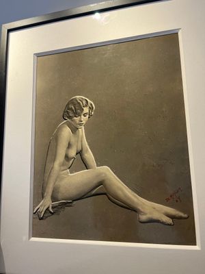 une photo d'une femme assise par terre devant un tableau