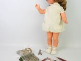 a doll that is standing next to a bunch of tools