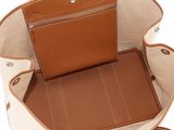 the inside of a tan and white purse with a brown handle