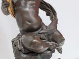 an antique bronze statue of a boy holding a bird on a pedestal