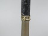 an antique brass and black marble cylinder with a gold trim