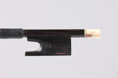 un gros plan d'un archet de violon avec un manche en bois