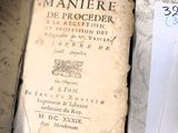 un vieux livre posé sur une table à côté d'une feuille de papier