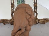 a statue of a woman holding a baby in front of a mirror