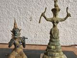 statue d'une femme tenant un bâton, à côté d'une statue d'un homme tenant un bâton