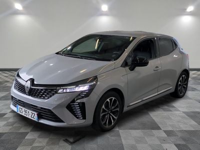 une voiture argentée est garée dans une grande pièce au sol en damier