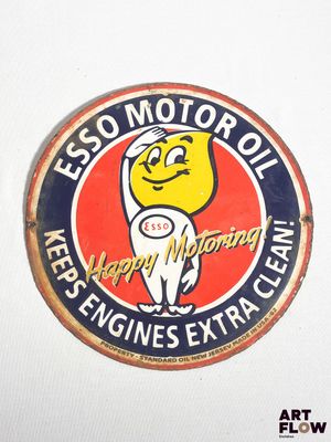 un panneau portant l'inscription « Esso Motor Oil » sur le côté d'un mur blanc