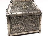 an old silver box with a design of animals on it