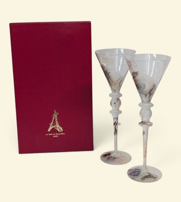 deux verres à vin dans une boîte, avec une boîte rouge en arrière-plan