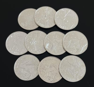 six pièces d'argent de 25 centimes disposées en pyramide sur une surface noire