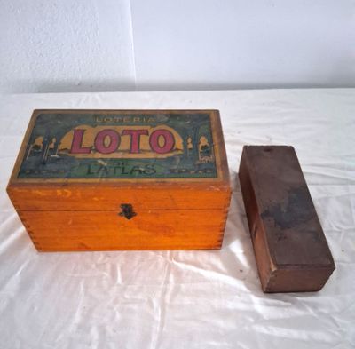 une petite boîte en bois avec un couvercle, posée sur un lit
