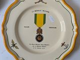 a plate with a medal on it next to a cup