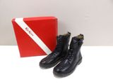 the black boots are next to a red box on the table
