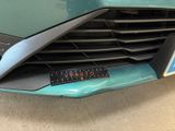 a close up of a car ' s grille with a sticker on it