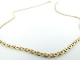 gros plan d'un collier à chaîne en or sur une surface blanche