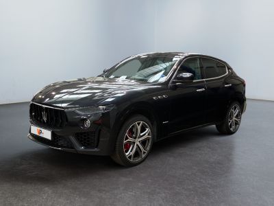 Une voiture « mas » noire est garée dans une pièce blanche
