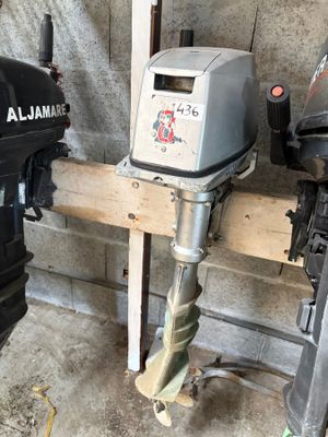 deux moteurs hors-bord posés sur un support en bois dans un garage