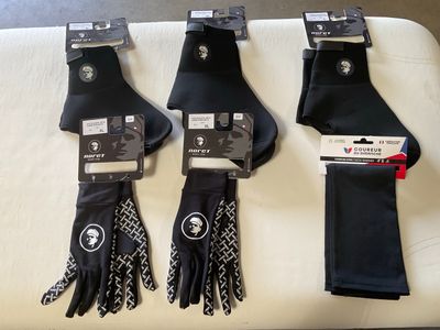 three pairs of black gloves and a pair of black gloves on a white table