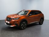 un SUV orange garé dans une pièce aux murs blancs