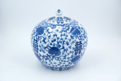 a blue and white vase with a lid on a white surface