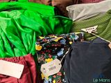 a pile of clothing that is sitting on a bed