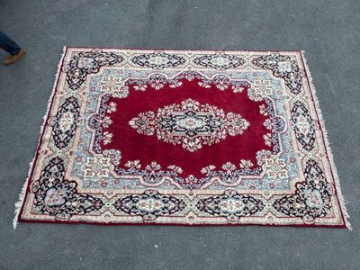 an oriental rug on the ground with a person walking by
