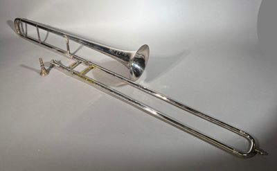 le trombone est posé sur une surface blanche, avec un fond blanc