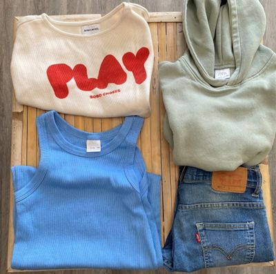 three pairs of blue jeans and a white shirt with the word play on it